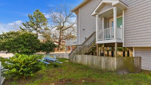A two-story house with a covered porch and a wooden fence.