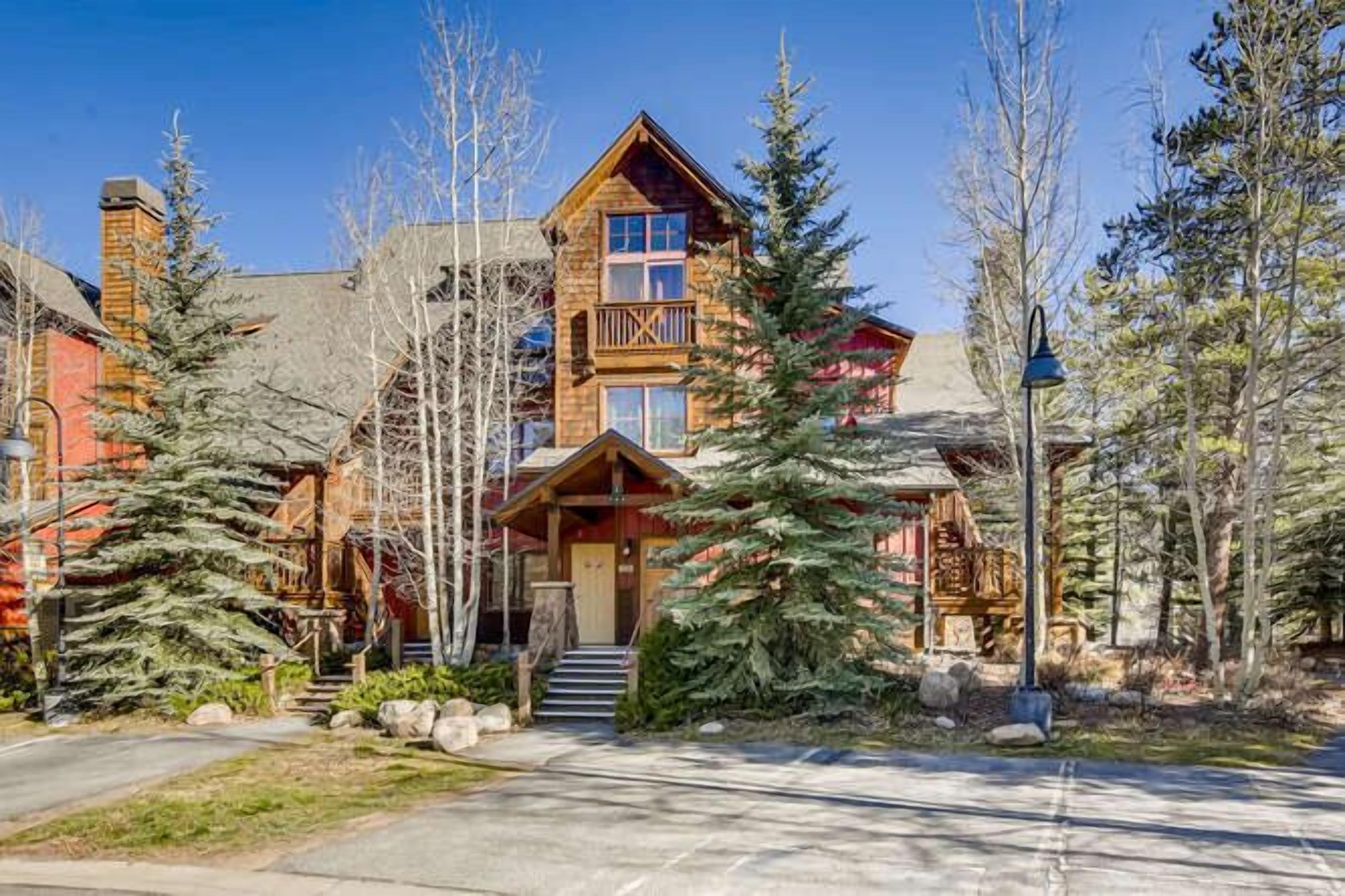Un chalet doté d’une façade en bois remarquable, d’un balcon et d’un escalier menant à l’entrée.