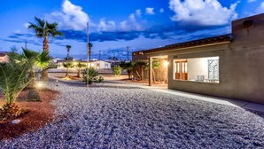 A building with a gravel driveway and palm trees.