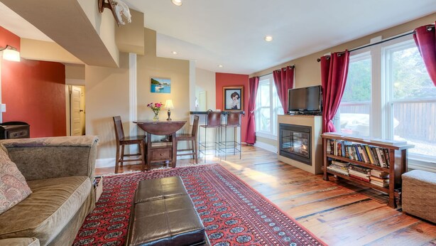 Ein gemütliches Wohnzimmer mit Kamin, Fernseher und Bücherregal.