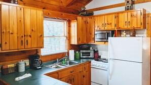 A kitchen with wooden cabinets, a microwave, a stove, and a refrigerator.