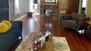 A living room with a fireplace, a sofa, a coffee table, and a television. - Stunning contemporary North Shore Bungalow with hot tub. Steps to everything.  (Chattanooga)