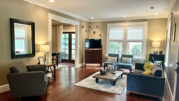A spacious living room with hardwood floors, a television, and comfortable seating. - Stunning contemporary North Shore Bungalow with hot tub. Steps to everything.  (Chattanooga)