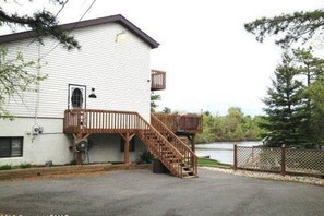 Un bâtiment blanc avec un escalier en bois menant à une terrasse.