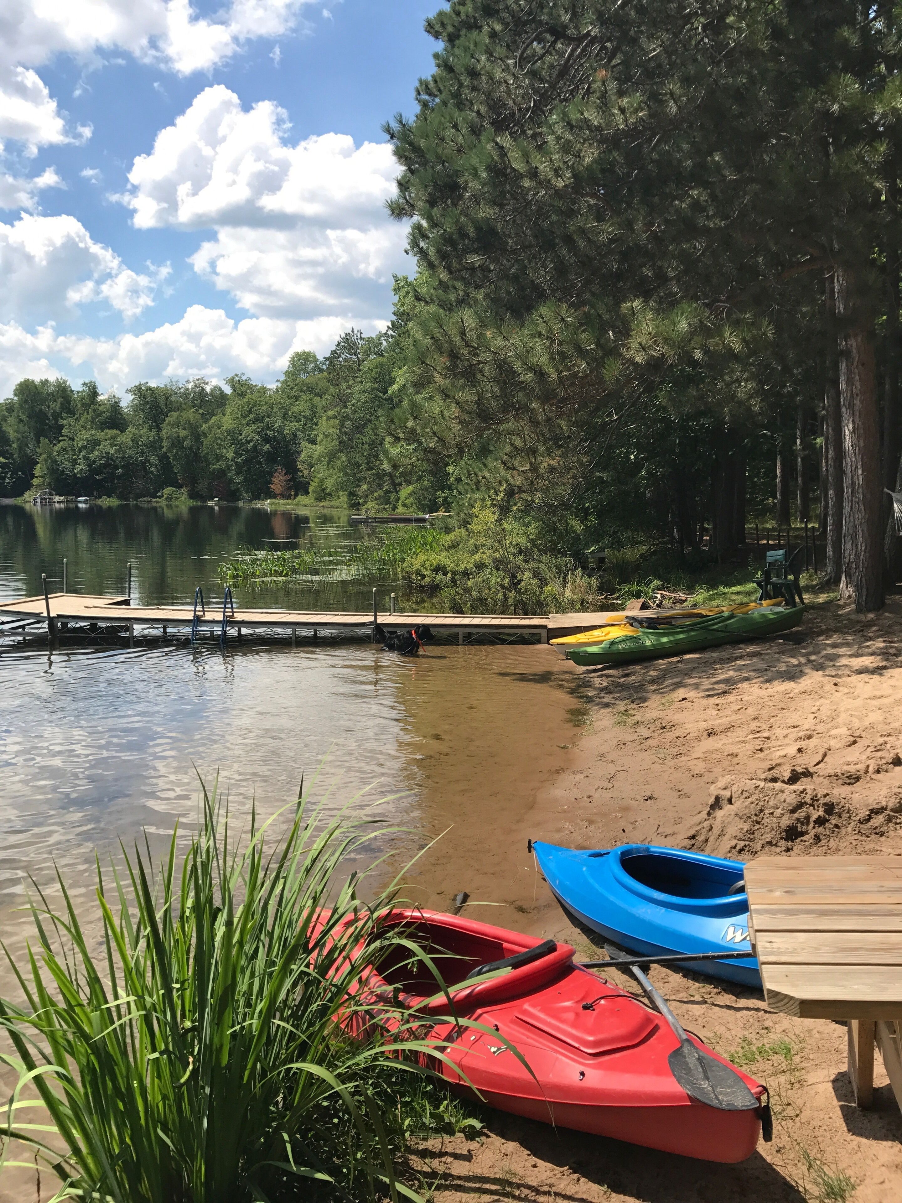 Eine Seenlandschaft mit Kajaks und einem Steg.