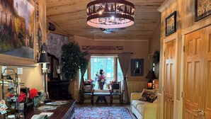 Un interno in legno con zona pranzo, un lampadario e vista attraverso una finestra.
