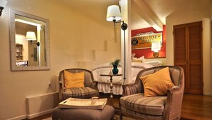 A cozy living room with two armchairs, a small table, and a mirror on the wall. - Cozy Studio Apartment with European style (Laguna Beach)