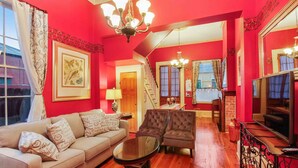 Un salon avec un canapé, des fauteuils, une table basse et un téléviseur.