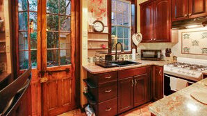 Une cuisine avec des meubles de rangement en bois, une cuisinière, un four à micro-ondes et un évier.