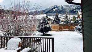 A snowy landscape with mountains in the background, a wooden fence, and a snow-covered chair. - Your Base Camp for Big Sky’s Best Runs. Plan your Montana Adventure today! (Big Sky)