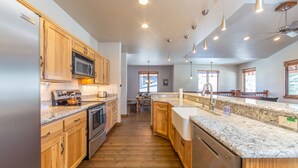 A modern kitchen with wooden cabinets, stainless steel appliances, granite countertops, and pendant lighting. - Your Base Camp for Big Sky’s Best Runs. Plan your Montana Adventure today! (Big Sky)