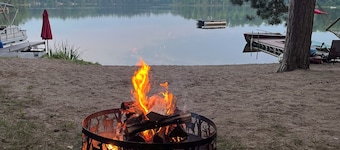 cabane en rondins au bord du lac paisible, vierge sur une grande plage avec l'eau claire