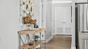 A modern kitchen with white cabinets, a stainless steel refrigerator, and a wooden dining table. - Luxurious Downtown-2 bed 2 bath Corner 2M (Nashville)