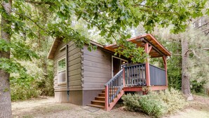 Une cabane avec une façade en bois, une véranda et un escalier menant à une terrasse.