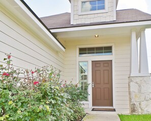 A house with a brown front door, a small porch, and a window above the door. - Casa di Vino - Backyard BBQ near Messina Hof (Bryan)