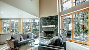 A spacious living room with a fireplace, large windows, and a cozy seating area.
