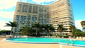 A large hotel with multiple balconies, a swimming pool, and palm trees. - SEA MAR CONDO: 19th Floor Penthouse South Seas Tower 4 With Awesome Views (Marco Island)