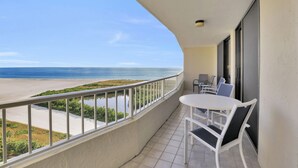 A balcony with a view of the beach, a round table with chairs, and a small seating area. - SEA MAR CONDO: 19th Floor Penthouse South Seas Tower 4 With Awesome Views (Marco Island)