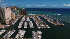 A marina with numerous boats docked in rows, surrounded by high-rise buildings and a clear view of the ocean. - Ocean View Condo - Ilikai Marina Waikiki Honolulu (Honolulu)