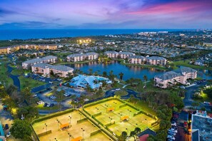 Ein Resort mit mehreren Gebäuden, einem zentralen See und Tennisplätzen.