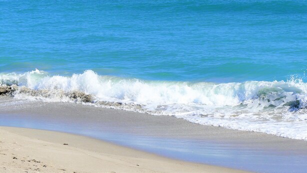 A beach with waves crashing onto the shore. - POSHPADZ -Villa Koalua Walk to Jupiter Beach-Prime Lake Views-Resort Setting (Jupiter)