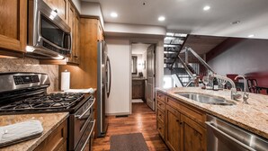 A modern kitchen with wooden cabinets, stainless steel appliances, and a granite countertop. - Wonderful Park City Townhome | Hot Tub | Mountain Views | Private Garage (Park City)