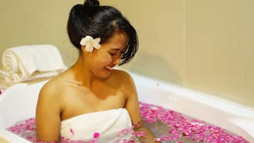 Guests can unwind in a serene bathtub surrounded by rose petals.
