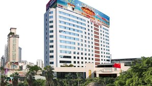 A multi-story hotel with a prominent advertisement on the top. - Xiamen Plaza Hotel (Xiamen)