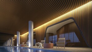 A modern indoor pool area with a clear pool, lounge chairs, and a wooden ceiling design. - Wyndel Apartments Riverside on Collins (Docklands)