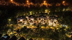 A resort with multiple buildings surrounded by palm trees at night. - Casa Marina Resort (Quy Nhon Nam)