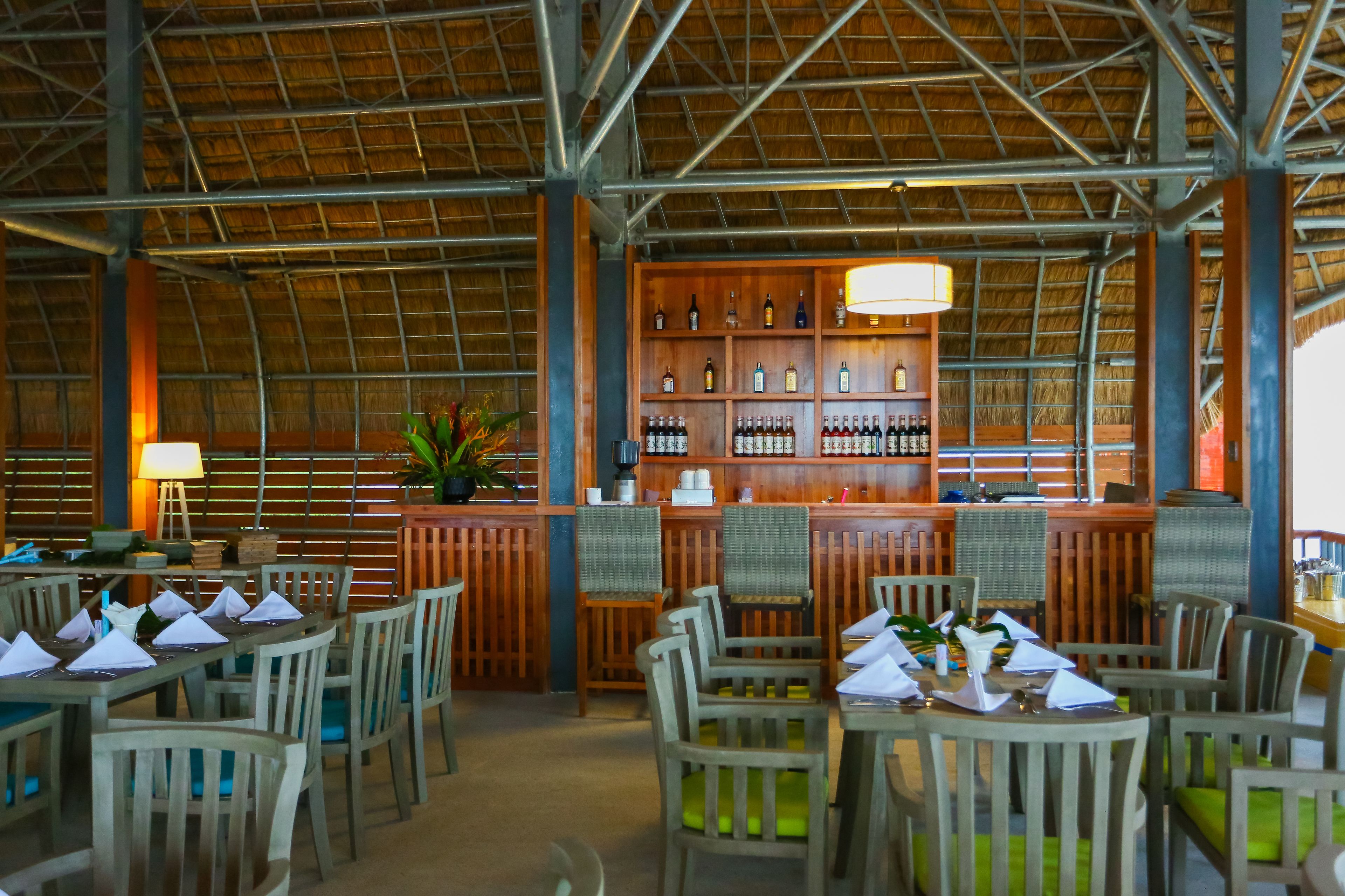 A restaurant with wooden furniture and a bar area.