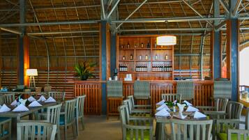 A restaurant with wooden furniture and a bar area.