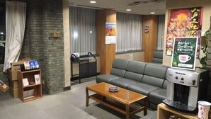 A seating area with a sofa, a coffee machine, and a small table.