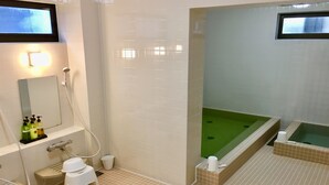 A bathroom with a bathtub, toilet, and sink.