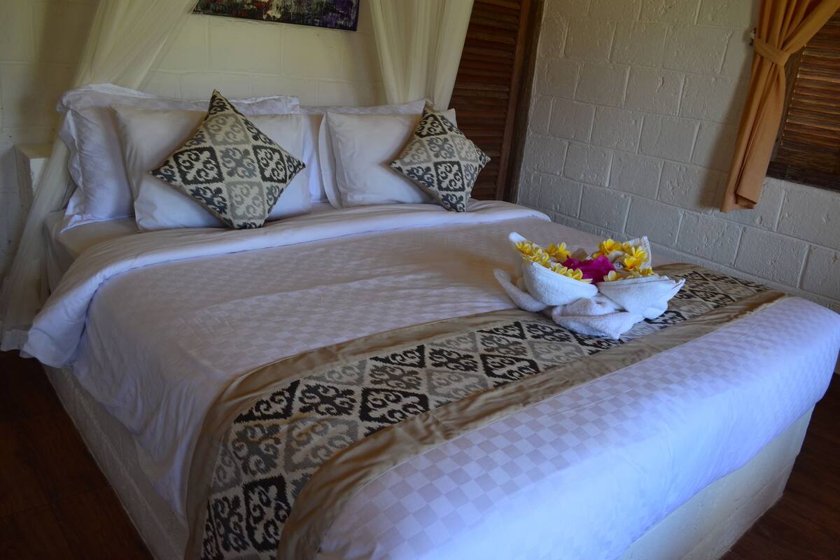 A neatly made bed with patterned pillows and a decorative pillow on the headboard.