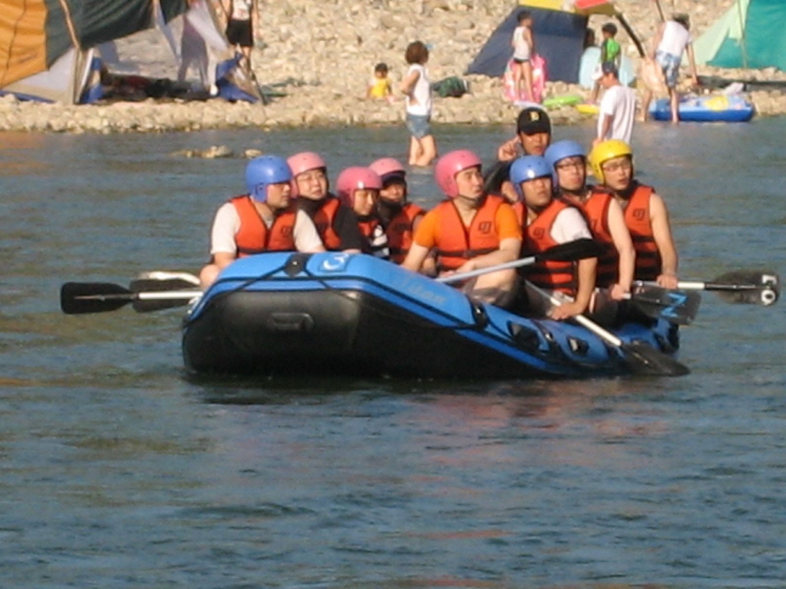 Eine Gruppe von Menschen in einer blauen Rauschenboje auf dem Wasser.