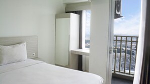 Una habitación de hotel con cama, ventana y vista de la ciudad.