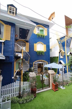 A two-story building with a blue exterior, yellow trim, and a white picket fence. - Xiamen Feisu Tianchunshe Holiday Villa (Xiamen)