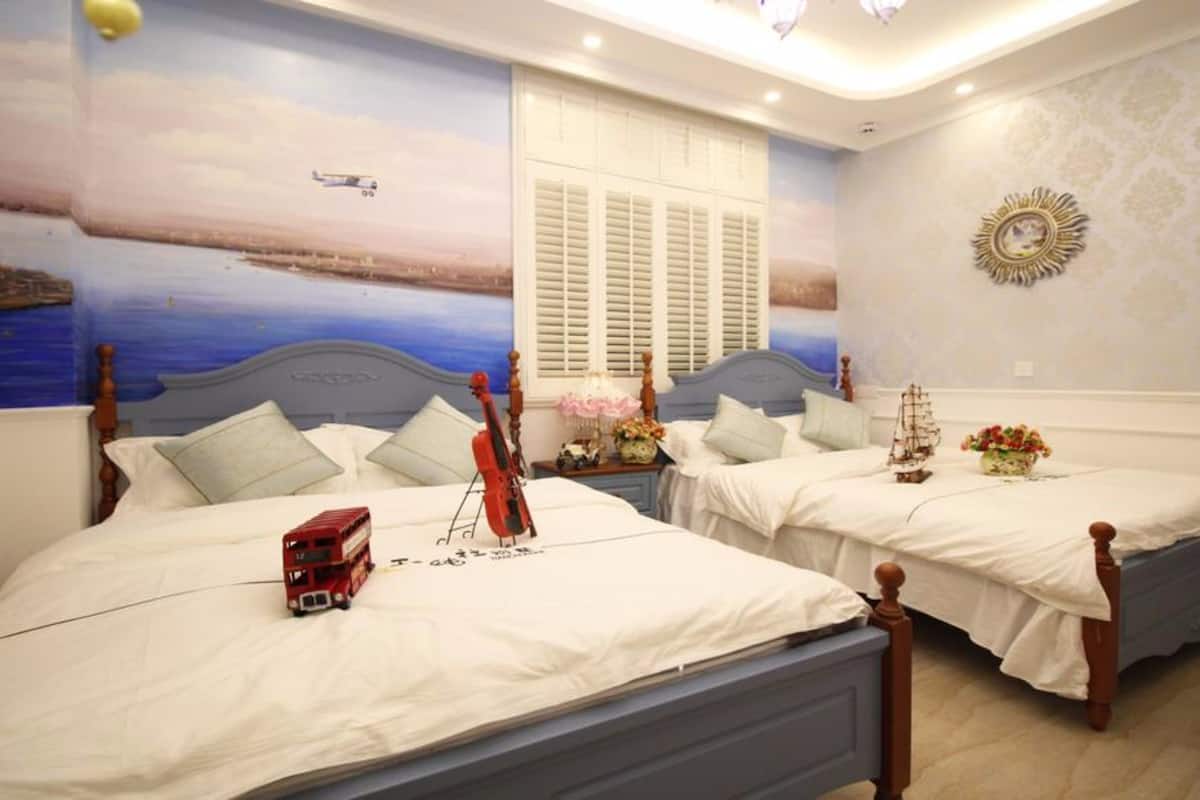 A hotel room with two beds, each with a white bedspread and a small ship model.