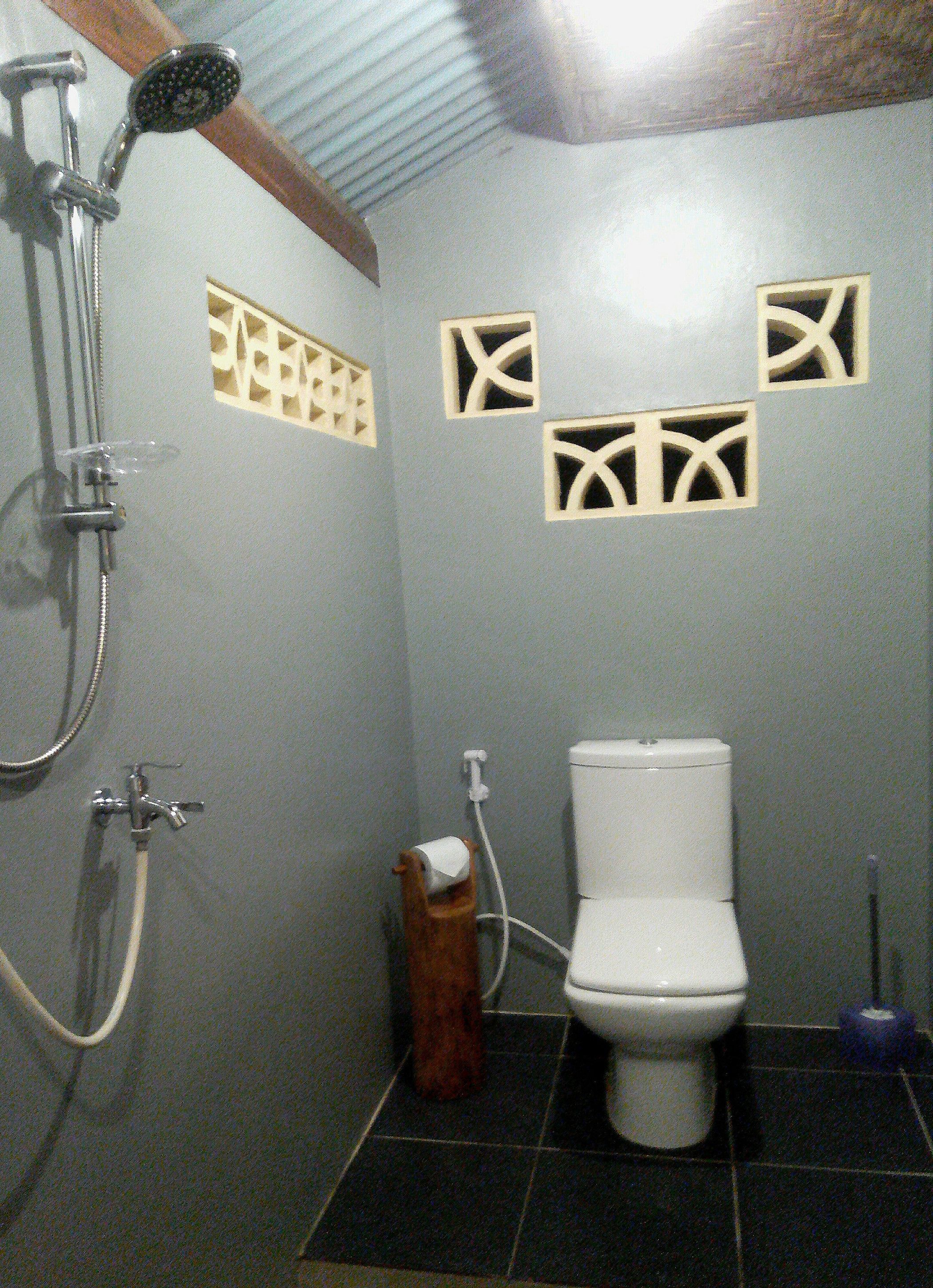 A bathroom with a shower, toilet, and a towel rack.