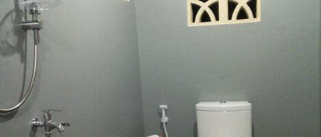 A bathroom with a shower, toilet, and a towel rack.