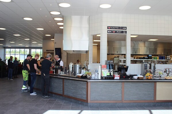 A buffet area with a coffee station, a salad bar, and a sign indicating the location of the toilet. - Rasta Värnamo (Varnamo)