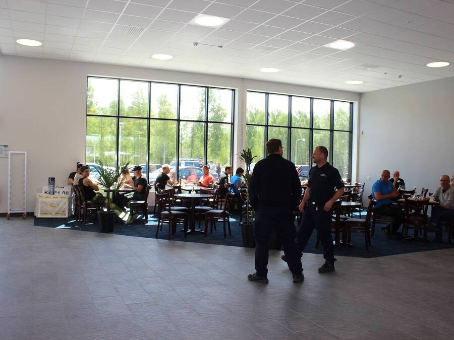 A spacious indoor dining area with large windows, multiple tables, and chairs.