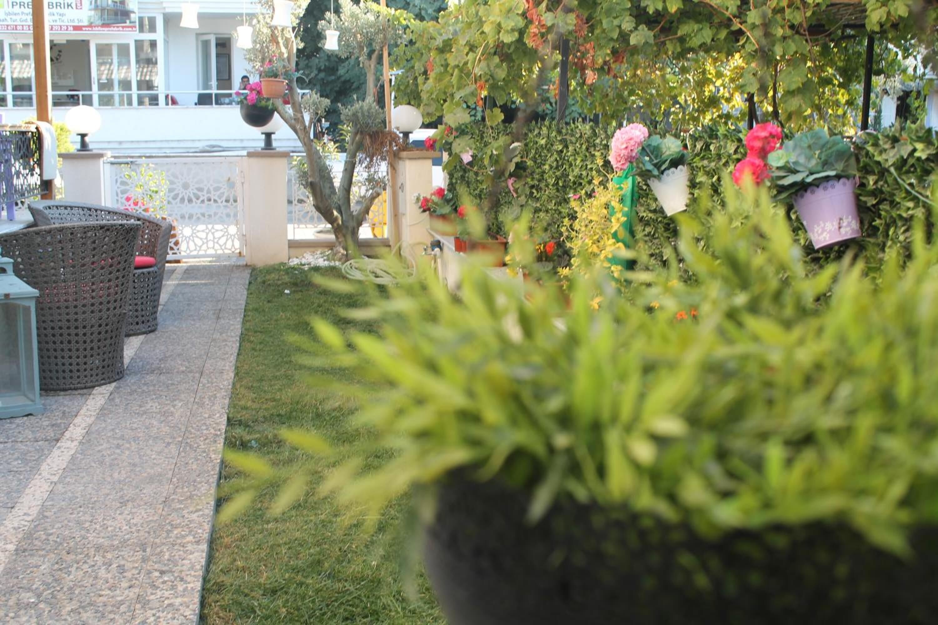 An outdoor seating area with wicker furniture and potted plants.