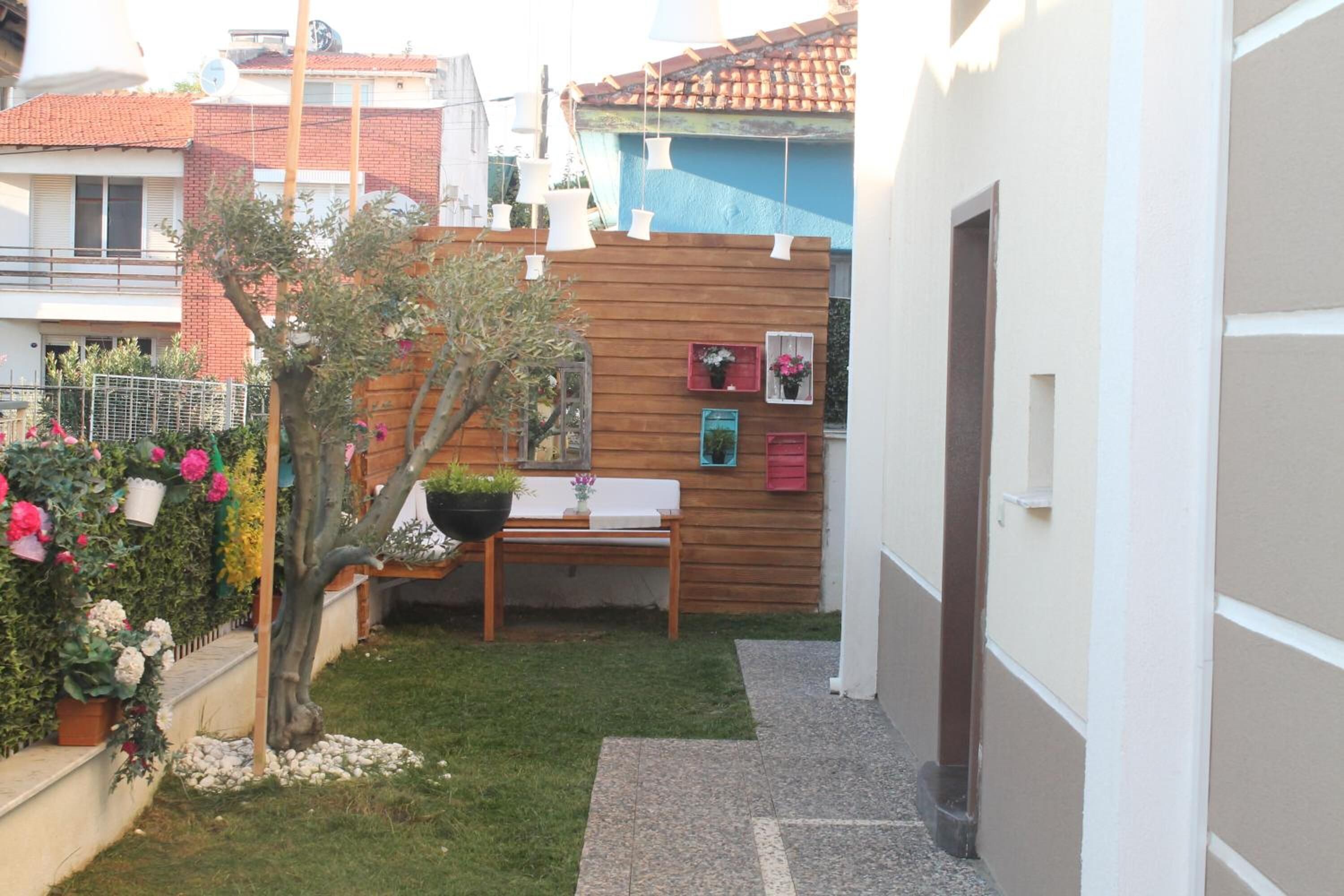 A small garden area with a wooden bench, a table, and a potted plant.