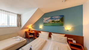 A hotel room with two beds, a desk, a chair, and a painting on the wall. - Hotel Löwen (Meckenbeuren)