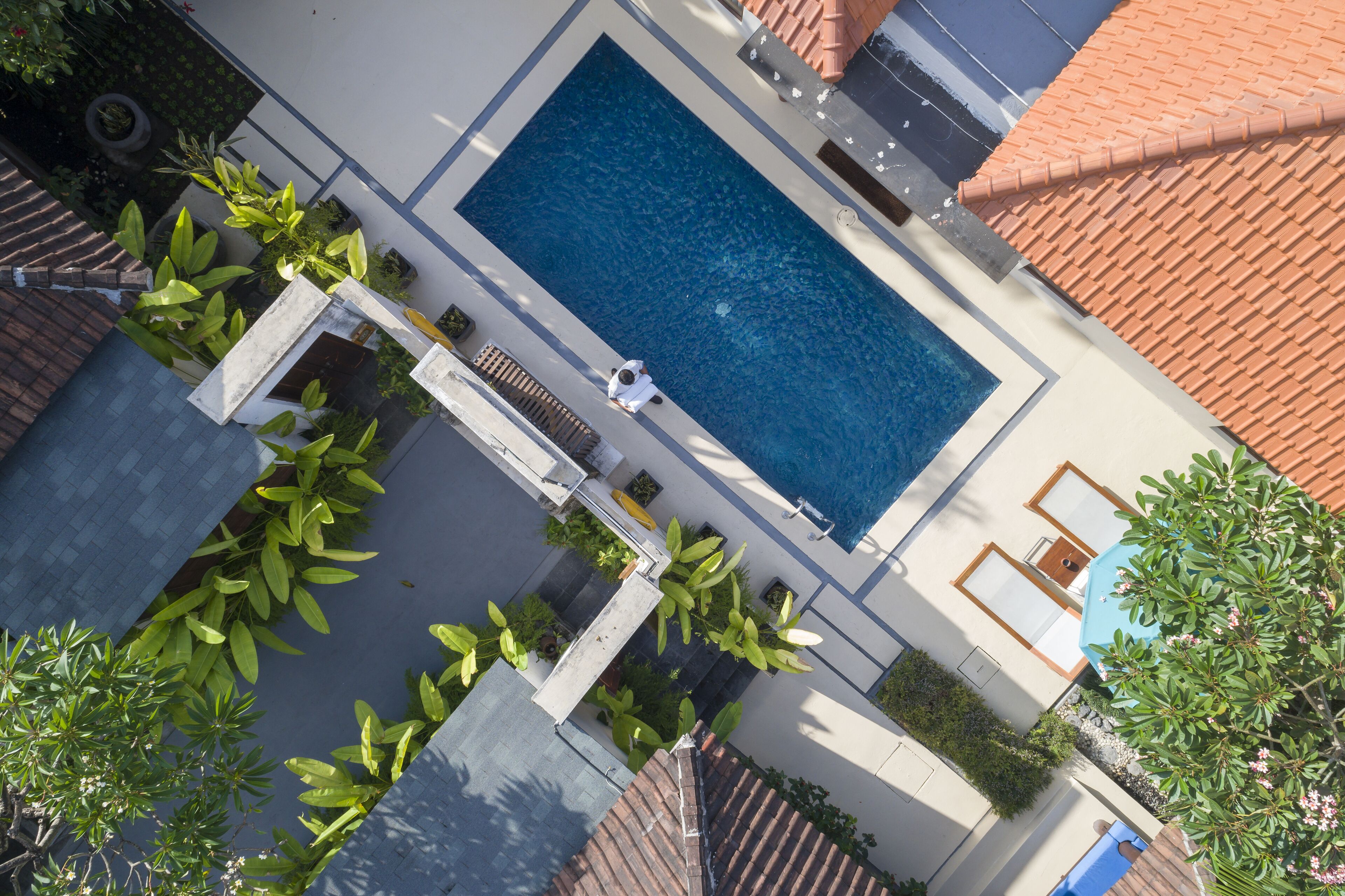Eine Vogelperspektive zeigt ein Wohnhaus mit Swimmingpool, Kübelpflanzen und einem Ziegeldach.
