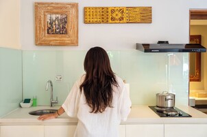 Una cucina con un fornello, un lavandino e un quadro appeso al muro.
