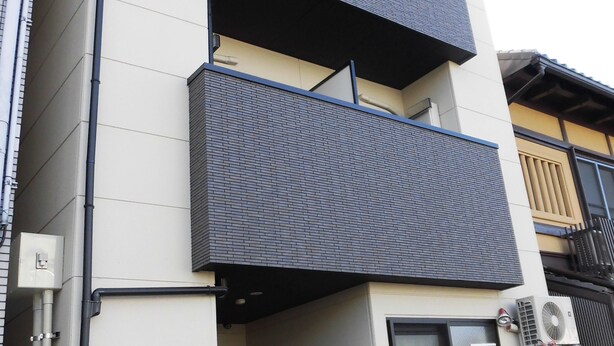 A modern building with a flat facade, multiple balconies, and a sign indicating an entrance. - KyotoHouseToji (Kyoto)