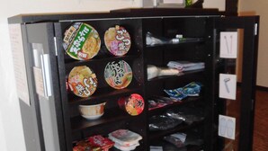 A vending machine with various packaged items, including instant noodles and snacks, in a hotel setting. - KyotoHouseToji (Kyoto)